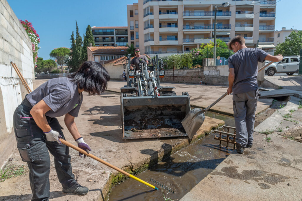 Photo de personne faisant l&#039;entretien des cours d&#039;eau avec un râteau, une pelle et une petite pelleteuse